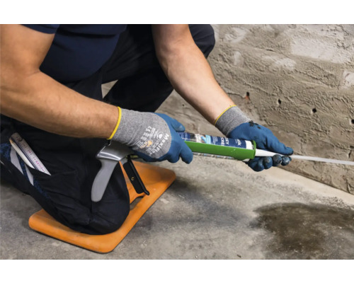 Un artisan utilise un pistolet à cartouche sur un chantier.