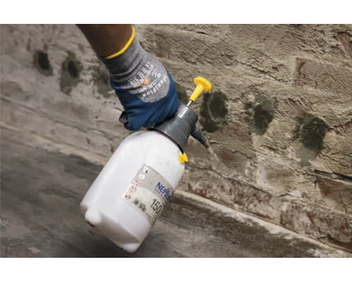 Application d''un pulvérisateur sur un mur en briques.