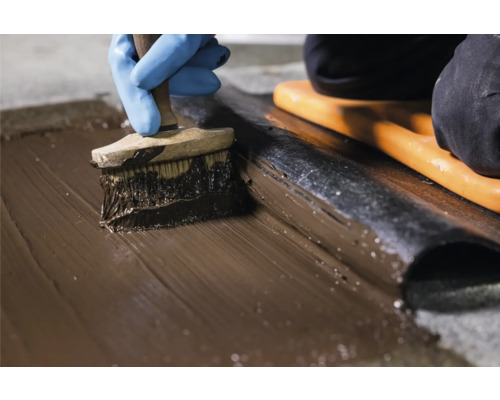 Application d''un produit d''étanchéité au pinceau sur une membrane de toiture.