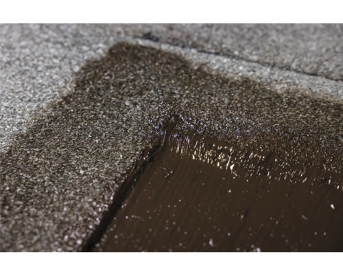 Gros plan sur la réparation de toiture avec revêtement bitumineux.