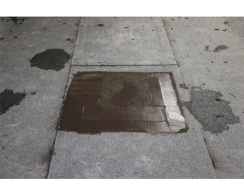 Réparation de toit plat avec du mastic bitumineux sur carton bitumé