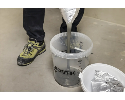 Fliessspachtel wird in einen Eimer gegossen