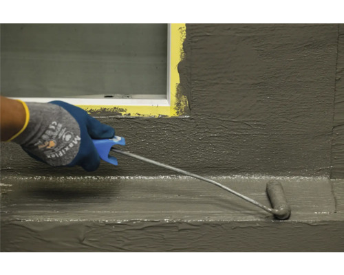 Auftragen einer Abdichtung mit einer Farbwalze im Innenbereich.