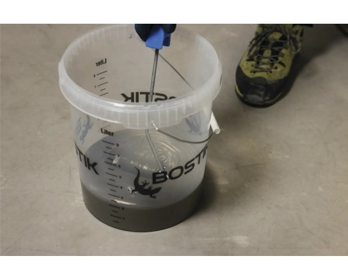 Mélange de chape Bostik dans un seau