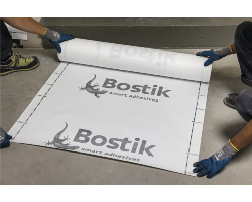 Une personne pose une membrane de désolidarisation Bostik sur le sol