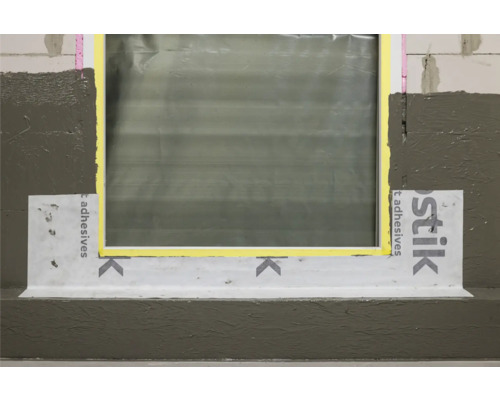 Raccord de fenêtre avec bande d''étanchéité et mastic d''étanchéité sur une façade.