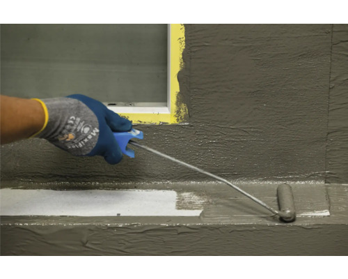 Une personne applique une couche protectrice sur une surface à l’aide d’un rouleau à peinture