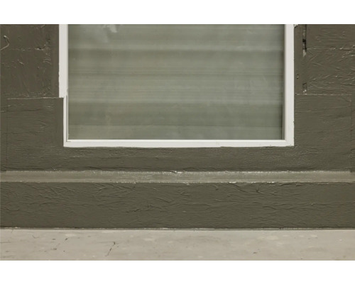 Gros plan d''une fenêtre de cave avec cadre et mur peints