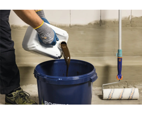 Flüssigkeit wird in einen Eimer gegossen, daneben eine Farbwalze