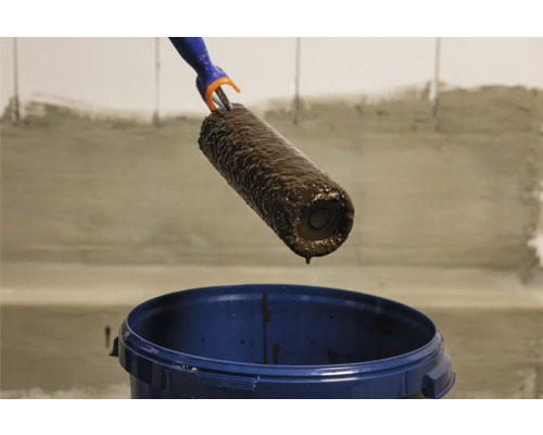 Farbroller über einem Farbeimer