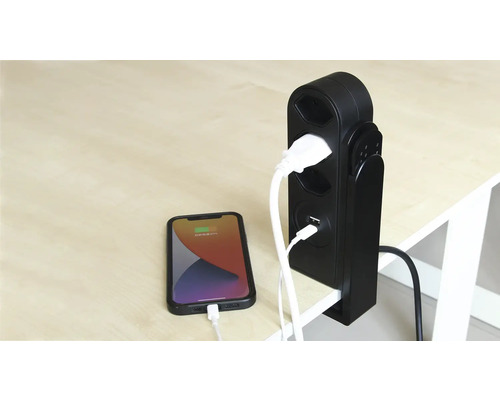 Multiprise avec port USB et téléphone portable connecté sur une table