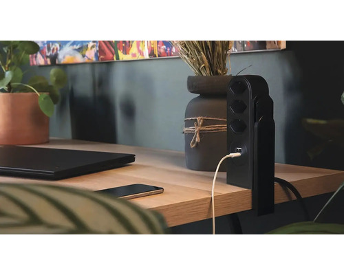 Multiprise avec port USB sur un bureau avec ordinateur portable et smartphone