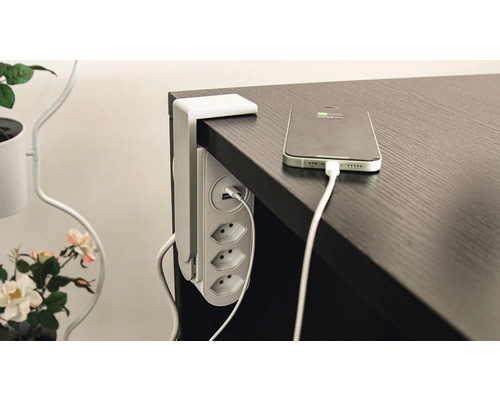 Multiprise de table avec connexion USB et smartphone chargé sur la table