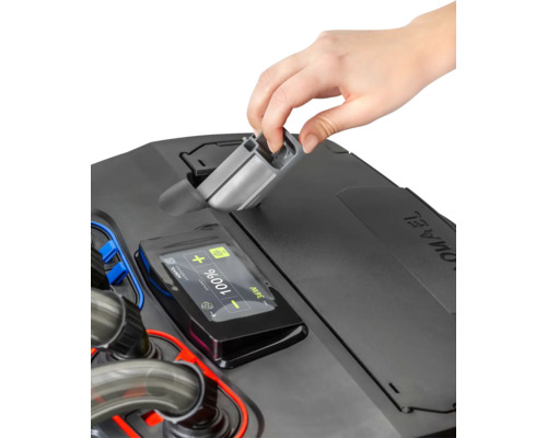 Une main place un distributeur automatique de nourriture Juwel sur un aquarium Juwel