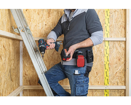 Handwerker mit Akkuschrauber, Werkzeuggürtel und Leiter bei der Arbeit