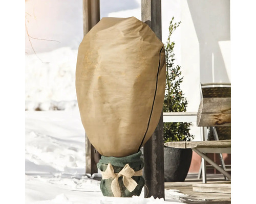 Plante en pot dans un sac de protection hivernale dans la neige