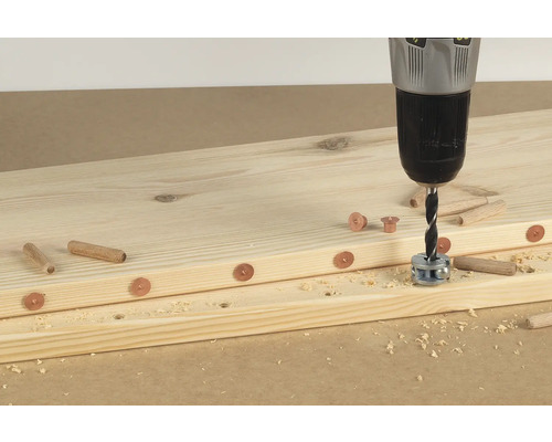 Holzbretter werden mit einem Dübelbohrer und Dübeln verbunden