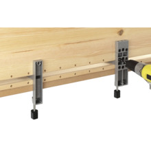 Holzbrett wird mit einer Bohrmaschine und einer Bohrlehre bearbeitet