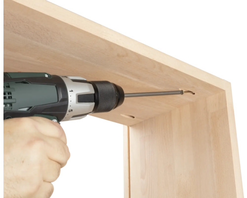 Artisan vissant une vis avec une visseuse sans fil dans un cadre en bois