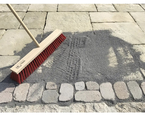 Besen zum Einkehren von Pflastersand auf einer gepflästerten Fläche