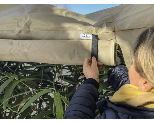 Une personne fixe une housse de protection avec une fermeture velcro à l''extérieur