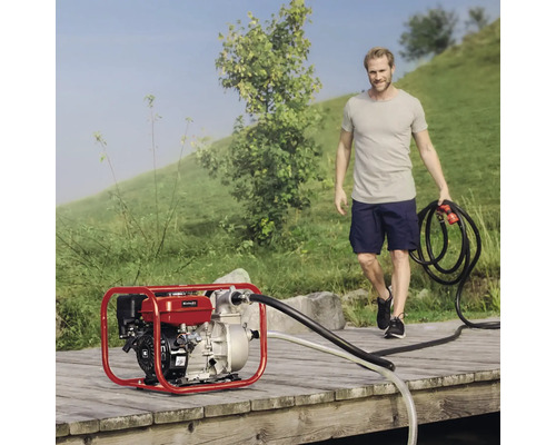 Pompe à eau à essence sur une passerelle en bois avec un homme tenant un tuyau