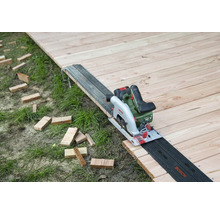 Akkukreissäge auf Holzboden mit Führungsschiene und Holzstücken