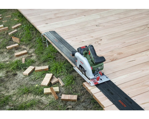 Akkukreissäge auf Holzboden mit Führungsschiene und Holzstücken