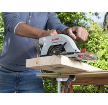 Eine Person sägt ein Holzbrett mit einer Bosch Handkreissäge.