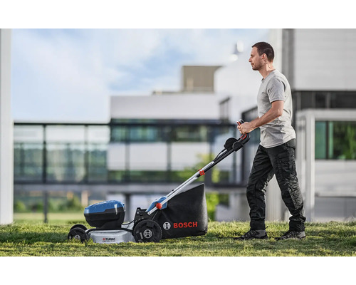 Un homme utilise une tondeuse à gazon sans fil Bosch dans le jardin.