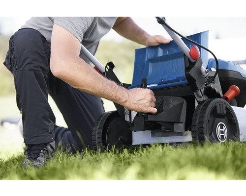 Une personne prépare une tondeuse à gazon pour le jardinage