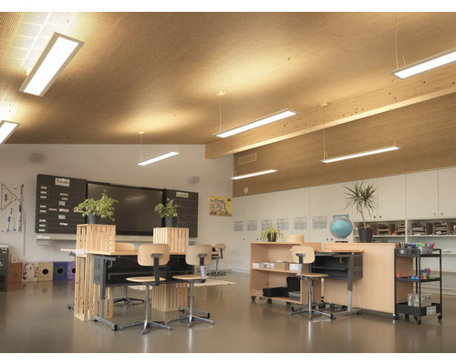 Heller Klassenraum mit Tischen, Stühlen, Tafeln und Regalen für den Unterricht