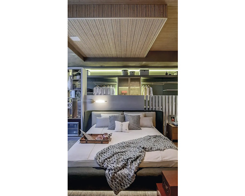 Helles Schlafzimmer mit Doppelbett, Kissen und Decke sowie Einbauschränken