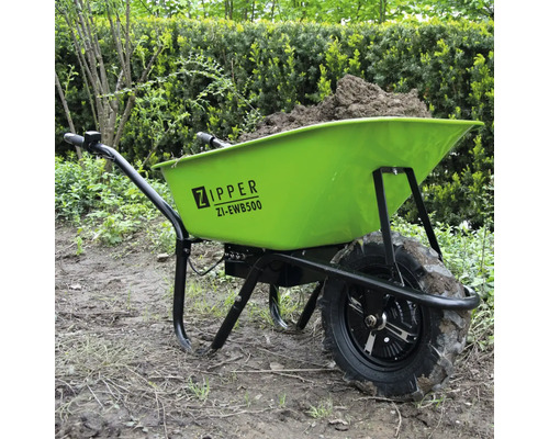 Brouette verte remplie de terre dans le jardin