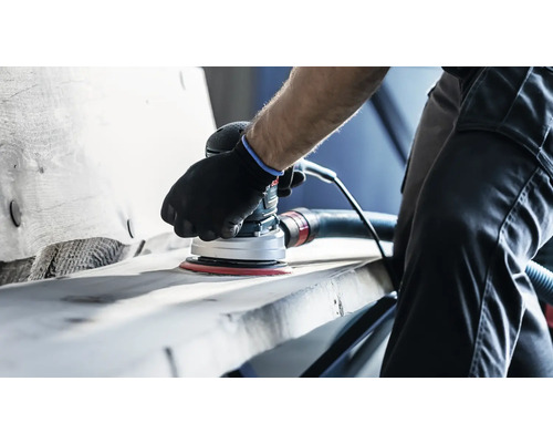 Une personne ponce une pièce à l''aide d''une ponceuse excentrique.