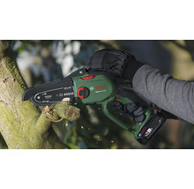 Person schneidet Ast mit Akku-Kettensäge von Bosch