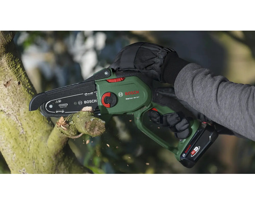 Person schneidet Ast mit Akku-Kettensäge von Bosch