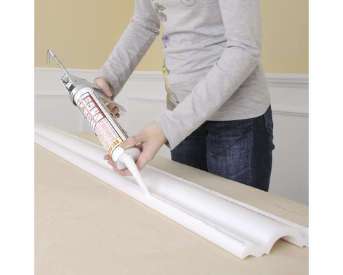 Application de mastic sur une moulure à l''aide d''un pistolet à cartouche.