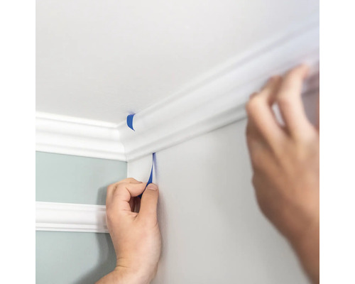Application de ruban de masquage sur un plafond et une moulure murale