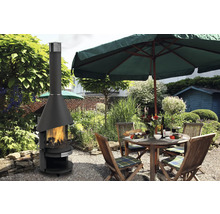 Jardin avec cheminée d''extérieur et table dressée sous un parasol