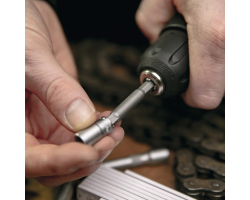 Un homme fixe un embout de vissage sur une visseuse sans fil.