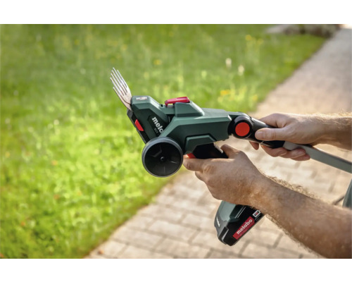 Person hält eine Akku-Fugenkratzbürste von Metabo in der Hand, um Fugen zu reinigen.