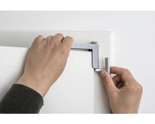 Person befestigt einen Türspion an einer Tür