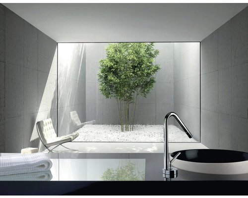 Modernes Badezimmer mit Waschbecken, Armatur und Blick auf einen Innenhof mit Bambus und weissem Kies