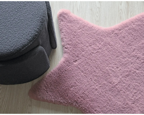 Tapis en forme d''étoile à côté d''un fauteuil gris sur plancher en bois