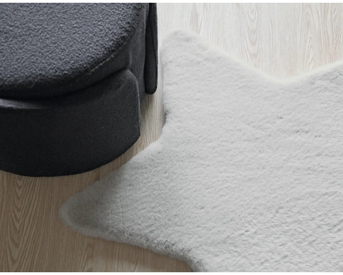 Sternförmiger Teppich neben einem Sessel auf einem Holzboden