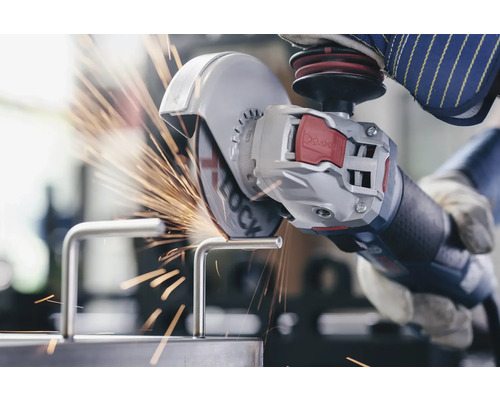 Une personne coupe une pièce métallique avec une meuleuse d''angle, ce qui produit des étincelles.