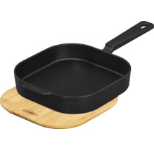 Poêle à griller noire en fonte sur planche en bambou