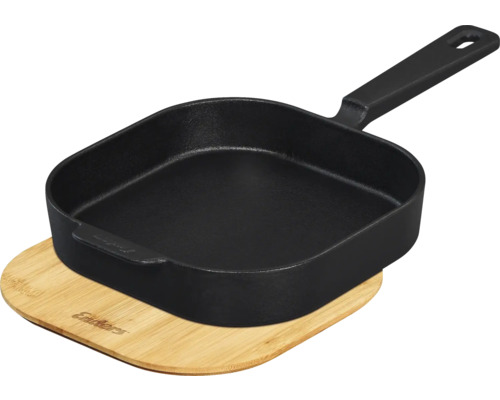 Poêle à griller noire en fonte sur planche en bambou