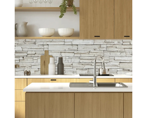 Cuisine lumineuse avec armoires en bois et mur en pierre